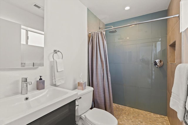 bathroom featuring toilet, vanity, and walk in shower