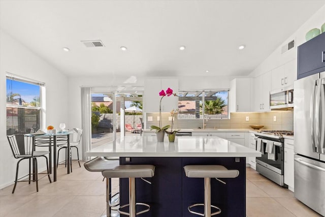 kitchen featuring a kitchen bar, a kitchen island, and appliances with stainless steel finishes