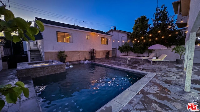 view of pool with pool water feature, an outdoor fire pit, and a patio