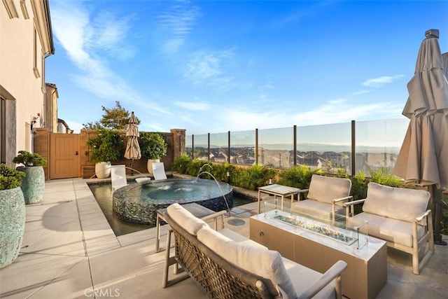 view of patio / terrace featuring pool water feature, a mountain view, and an outdoor living space with a fire pit