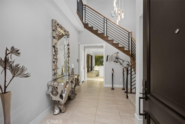 tiled entryway with a notable chandelier