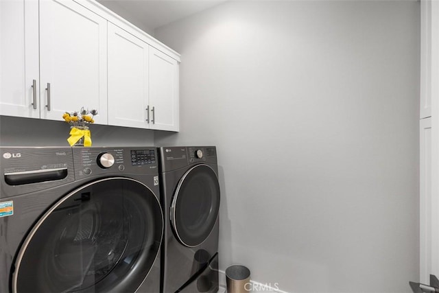 laundry area with cabinets and washing machine and clothes dryer