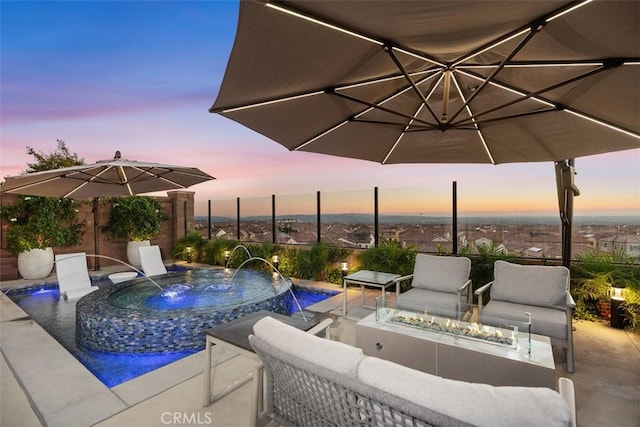 pool at dusk featuring an outdoor fire pit