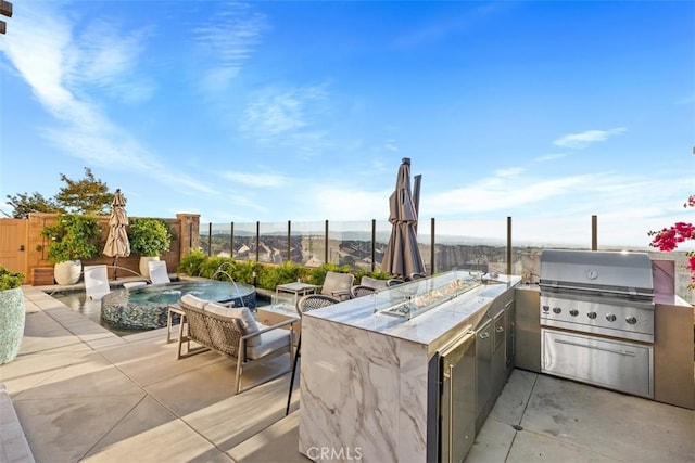 view of patio / terrace featuring a fenced in pool, grilling area, pool water feature, and exterior kitchen