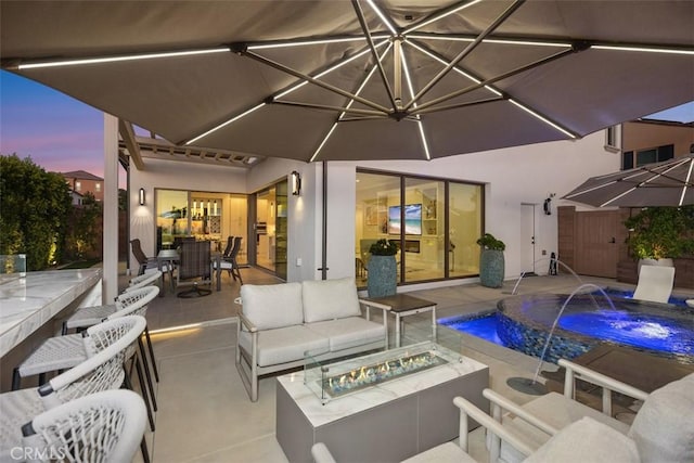 patio terrace at dusk featuring an outdoor living space with a fire pit