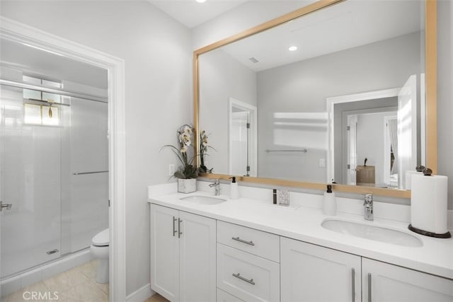 bathroom featuring tile patterned flooring, vanity, toilet, and a shower with shower door