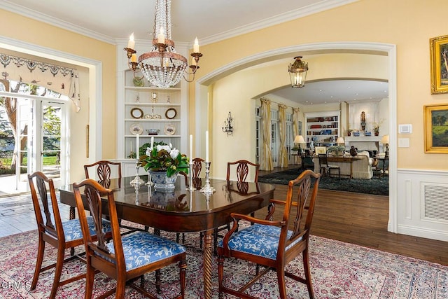 dining area featuring built in features, dark hardwood / wood-style floors, and ornamental molding