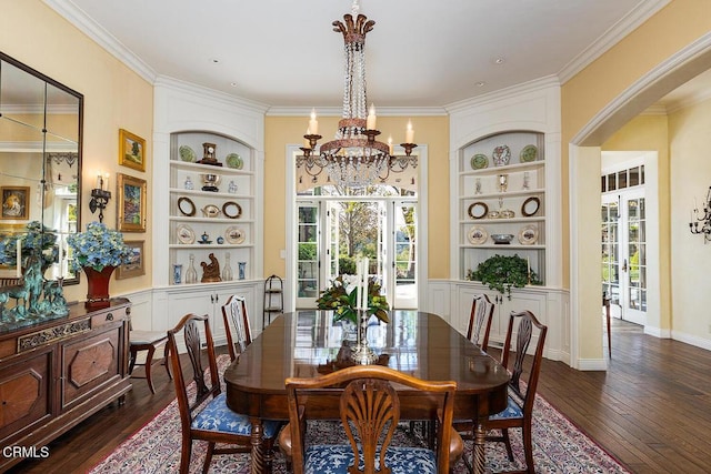 dining space with dark hardwood / wood-style flooring, built in features, ornamental molding, and a notable chandelier