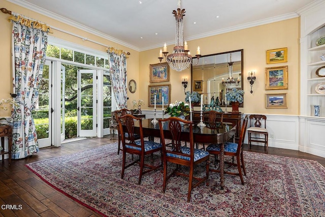 dining space featuring dark hardwood / wood-style floors, built in features, crown molding, and a chandelier