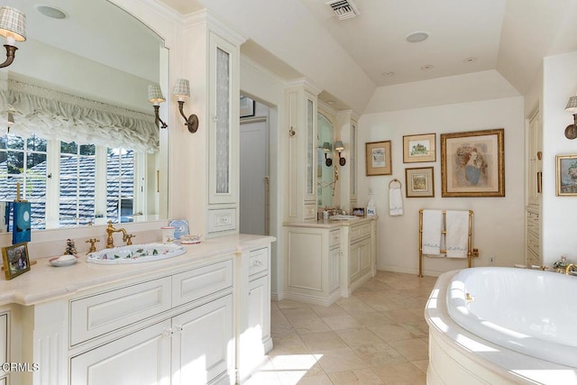 bathroom featuring tile patterned flooring, vanity, a bathtub, and lofted ceiling