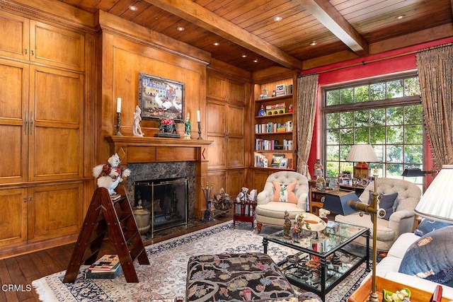 living room with a fireplace, beam ceiling, hardwood / wood-style flooring, and a wealth of natural light