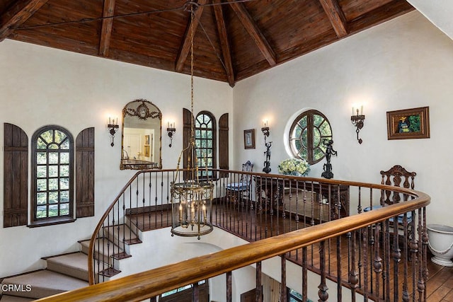 stairs featuring hardwood / wood-style floors, high vaulted ceiling, wood ceiling, and beamed ceiling