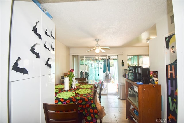 dining room featuring ceiling fan, a textured ceiling, and light tile patterned floors