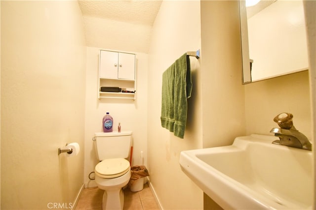 bathroom with tile patterned floors, sink, a textured ceiling, and toilet