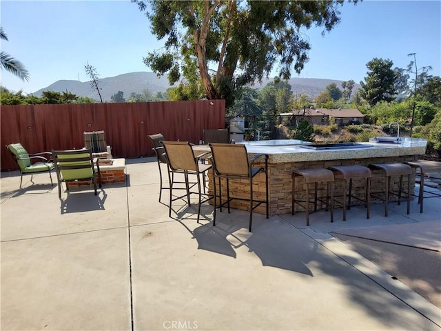 view of patio with a mountain view and a bar