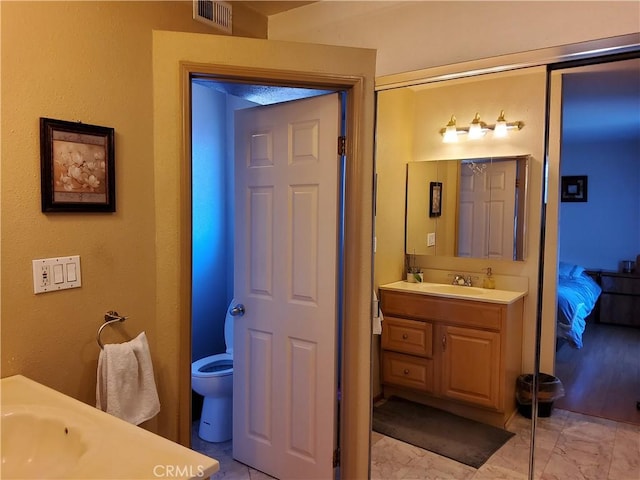 bathroom featuring vanity and toilet