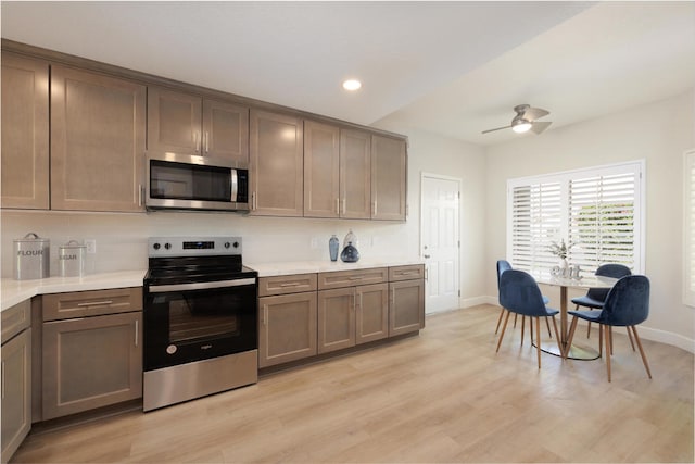 kitchen featuring ceiling fan, stainless steel appliances, and light hardwood / wood-style flooring