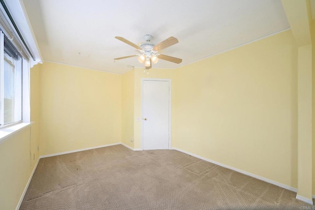 carpeted spare room featuring ceiling fan