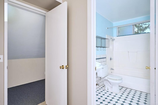 bathroom featuring vaulted ceiling, toilet, and shower / bath combination