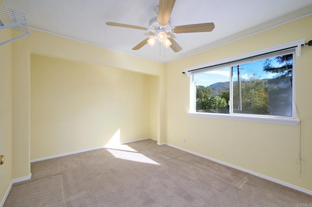 empty room with light colored carpet and ceiling fan