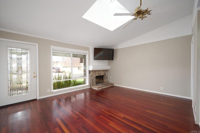 unfurnished living room with dark wood-type flooring, a fireplace, lofted ceiling with skylight, and ceiling fan