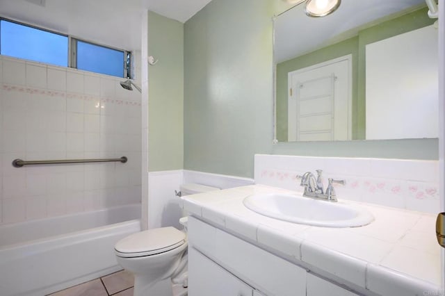 full bathroom featuring tiled shower / bath combo, vanity, tile patterned flooring, and toilet