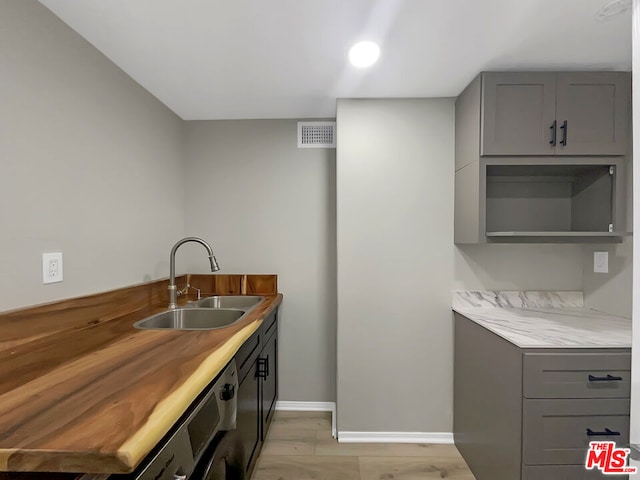 kitchen featuring light hardwood / wood-style floors, gray cabinets, and sink