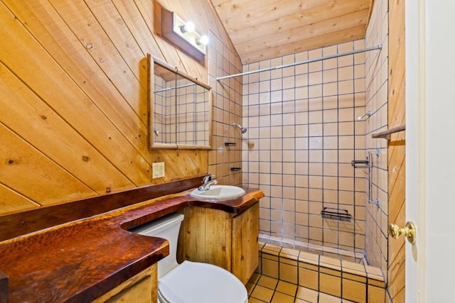 bathroom featuring vanity, toilet, tiled shower, and wood walls