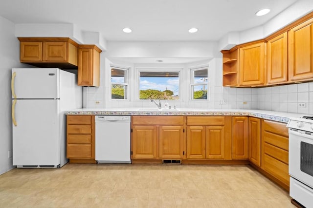 kitchen with sink, white appliances, and backsplash