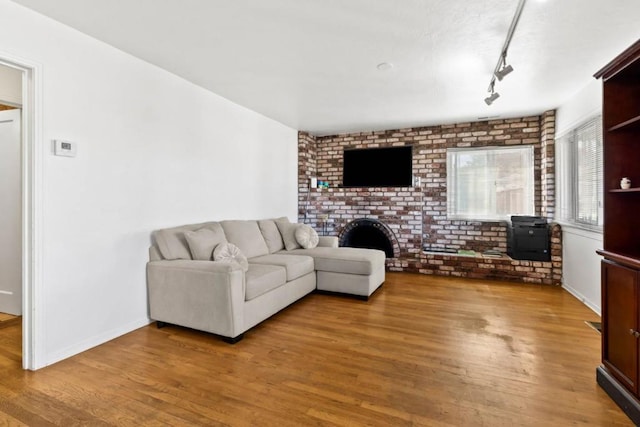 living room featuring brick wall and wood-type flooring