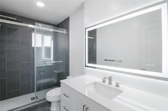 bathroom featuring toilet, vanity, walk in shower, and tile patterned flooring