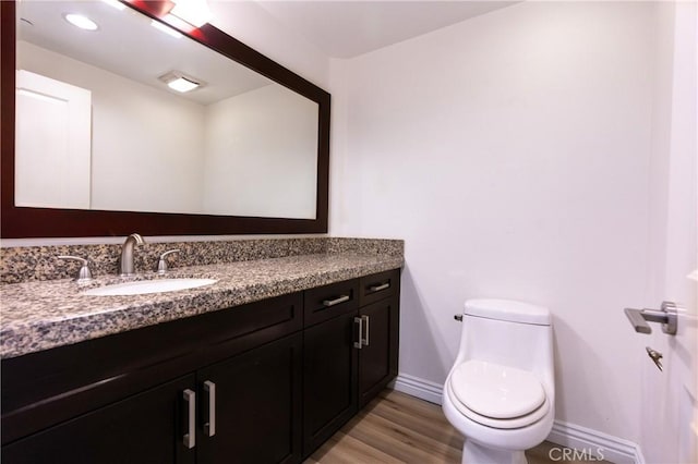 bathroom featuring hardwood / wood-style floors, vanity, and toilet