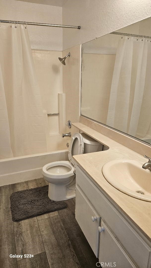 full bathroom featuring vanity, toilet, shower / bath combo, and hardwood / wood-style floors