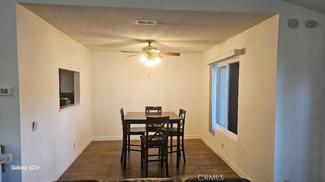 dining space featuring dark hardwood / wood-style floors, a textured ceiling, and ceiling fan