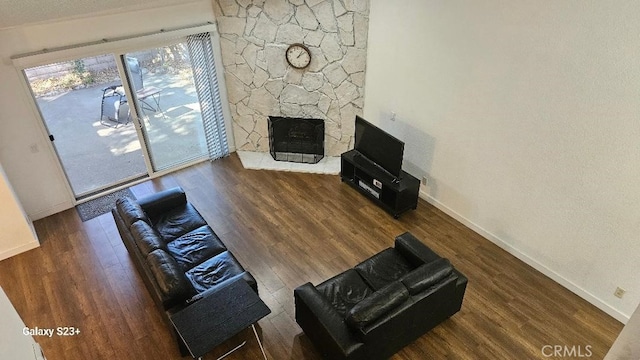 unfurnished living room featuring a stone fireplace and dark hardwood / wood-style flooring