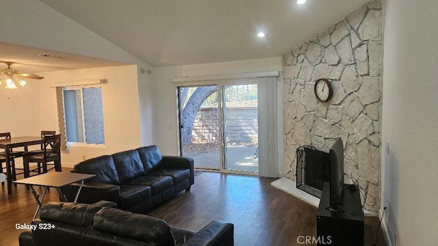 living room featuring lofted ceiling, ceiling fan, a fireplace, and dark hardwood / wood-style flooring