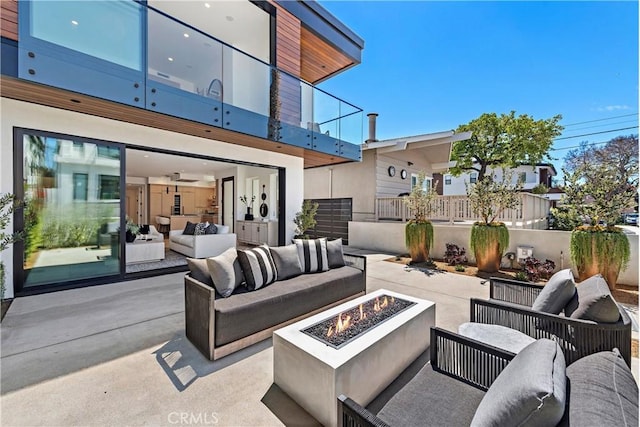 view of patio featuring an outdoor living space with a fire pit