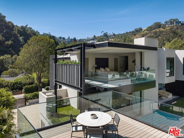 rear view of property with an outdoor living space and a wooden deck