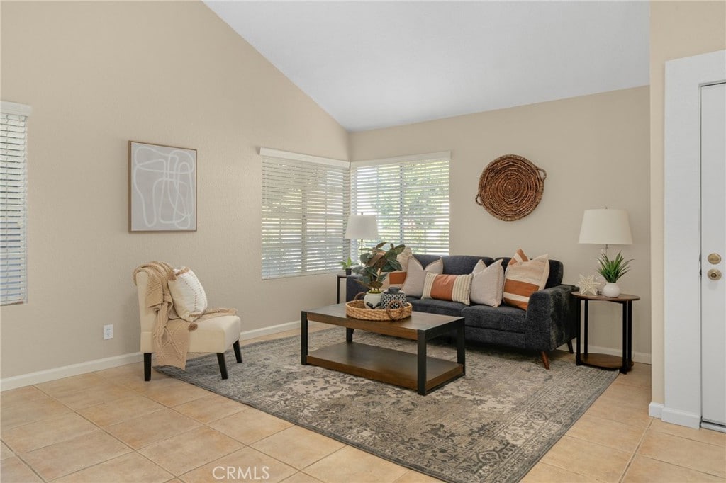 living room featuring light tile patterned floors and vaulted ceiling