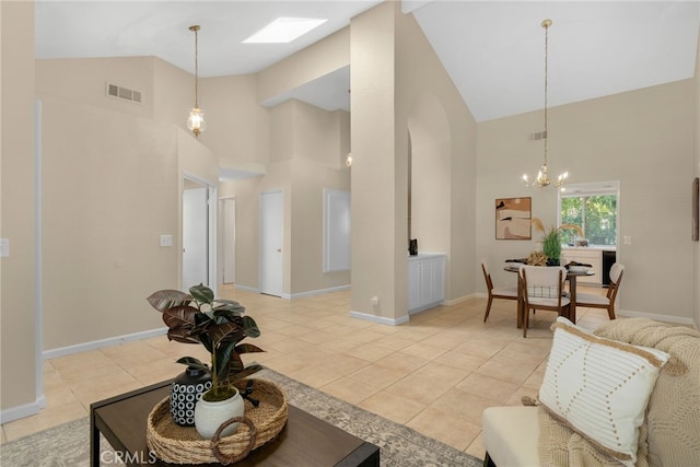 tiled living room featuring an inviting chandelier and high vaulted ceiling