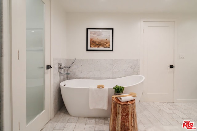 bathroom featuring a bathing tub and tile walls