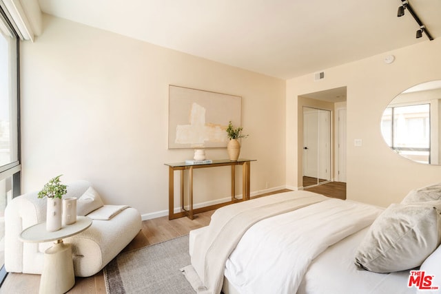 bedroom featuring light hardwood / wood-style flooring and track lighting