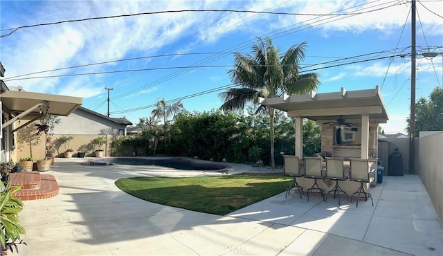 view of yard featuring ceiling fan, a fenced in pool, an outdoor bar, and a patio