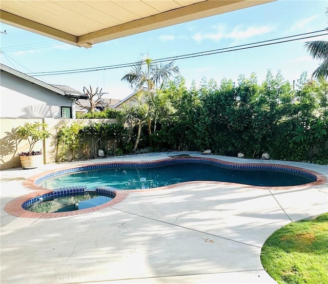 view of swimming pool with an in ground hot tub