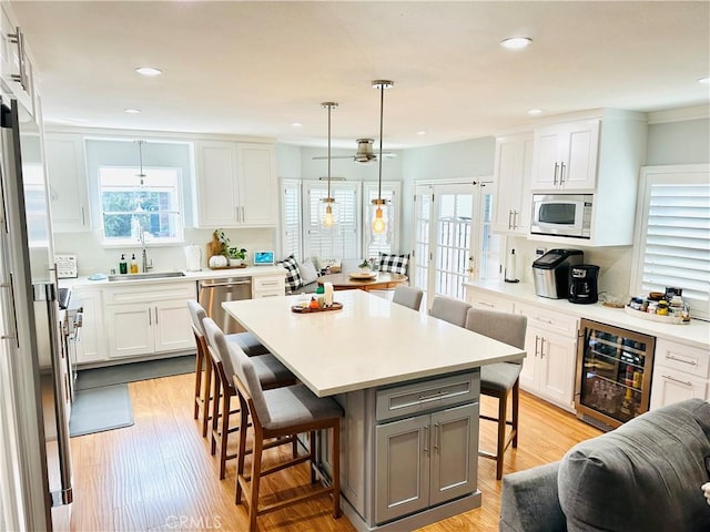 kitchen featuring white cabinetry, a breakfast bar, and beverage cooler