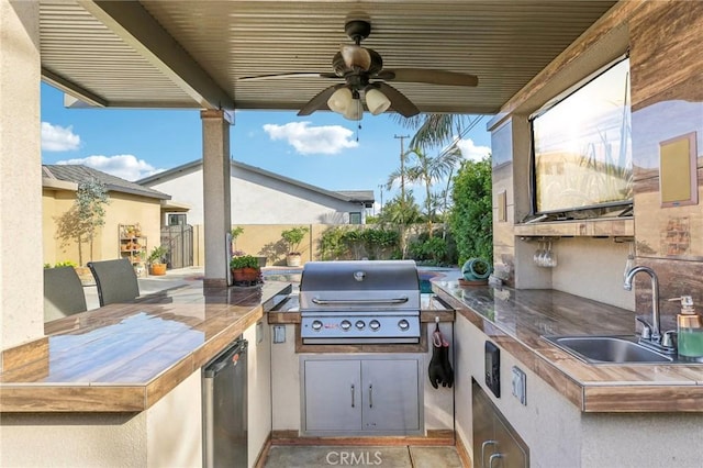 view of patio featuring sink, ceiling fan, exterior kitchen, and a grill