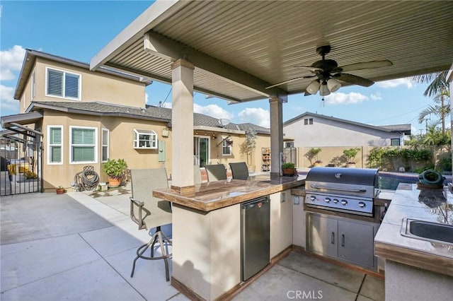 view of patio / terrace with ceiling fan, a grill, exterior kitchen, and exterior bar