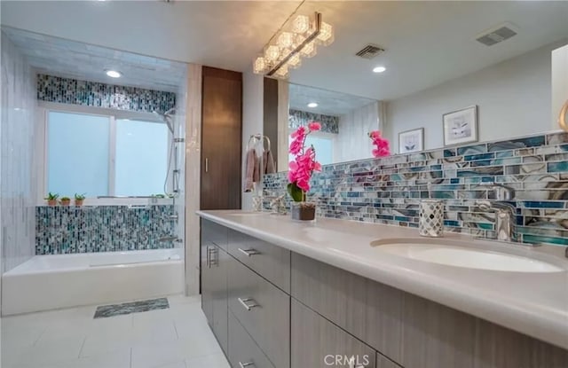 bathroom featuring vanity, a tub to relax in, tile patterned flooring, and backsplash