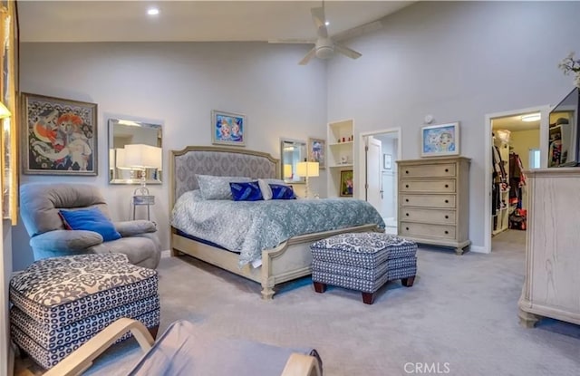 bedroom with a closet, a spacious closet, carpet floors, high vaulted ceiling, and ceiling fan