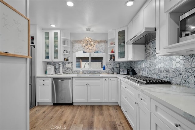 kitchen featuring appliances with stainless steel finishes, decorative light fixtures, and white cabinets